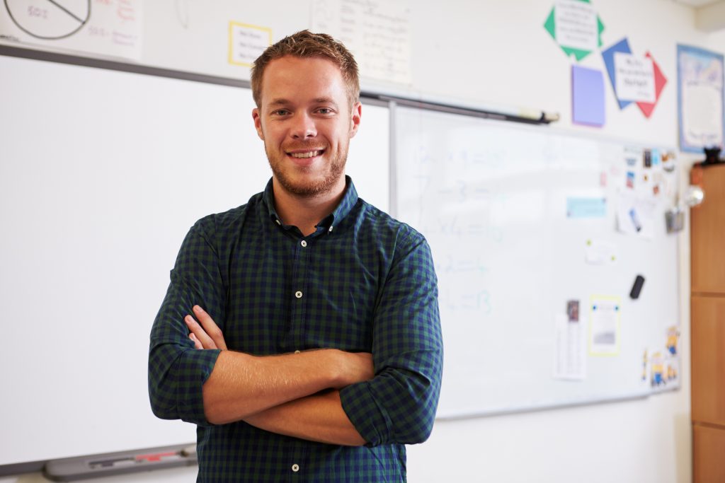 Portrait of confident male teacher in classroom