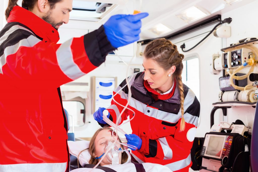 Emergency doctor and nurse or ambulance team transporting accident victim on stretcher