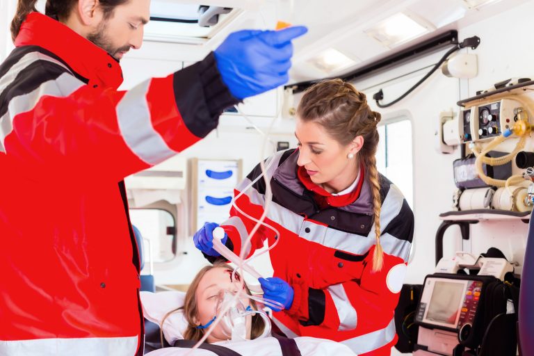 Emergency doctor and nurse or ambulance team transporting accident victim on stretcher