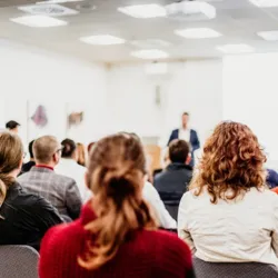 point-of-view of a student listening to a professor lecture at the front of the class