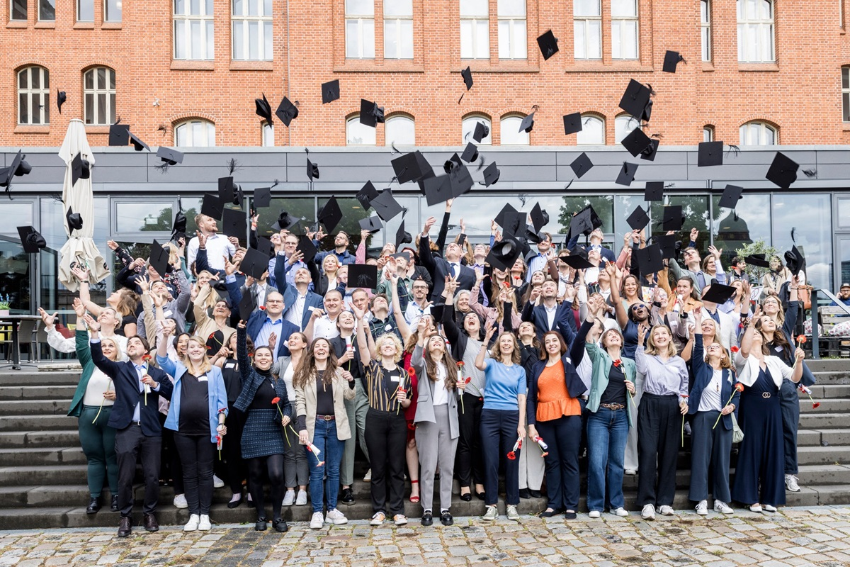 a group of recent graduations throw their caps into the air outside of the college