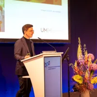 a man standing behind a podium on stage
