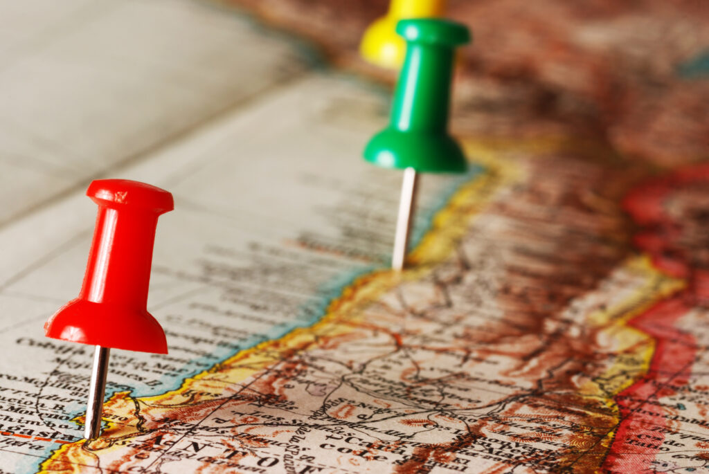Farbige Stecknadeln auf einer Landkarte zur Markierung von Standorten.