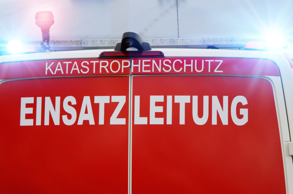 Einsatzleitfahrzeug des Katastrophenschutzes mit roter Rückseite und der Aufschrift „Einsatzleitung“, Blaulicht auf dem Fahrzeugdach.