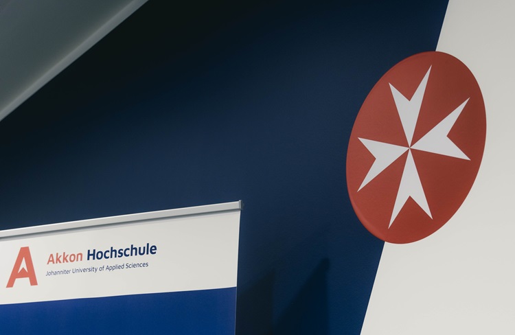 Roll-up mit Logo der Akkon Hochschule für Humanwissenschaften im Rahmen einer Veranstaltung.