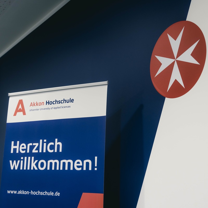 Ausschnitt einer Präsentationsfolie mit der Aufschrift „Herzlich willkommen!“ sowie dem Logo der Akkon Hochschule. Die Folie wird im Rahmen einer Einführungsveranstaltung für neue Studierende gezeigt.