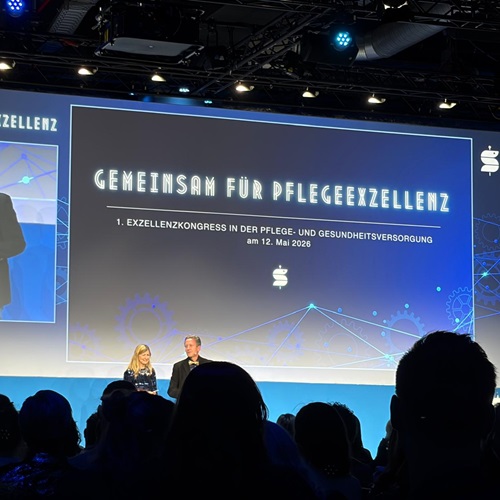 Bühnenaufnahme des Pflegeexzellenzkongresses 2026 mit Vortragssituation und großem Screen im Veranstaltungssaal. Der Kongress bringt Fachkräfte, Wissenschaft und Praxis aus Pflege und Gesundheitsversorgung zusammen.