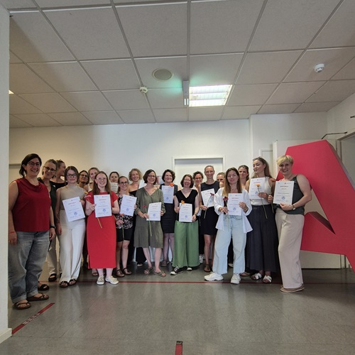 Gruppe von Absolventinnen und Absolventen mit Abschlusszeugnissen bei einer feierlichen Zeugnisübergabe an der Akkon Hochschule.