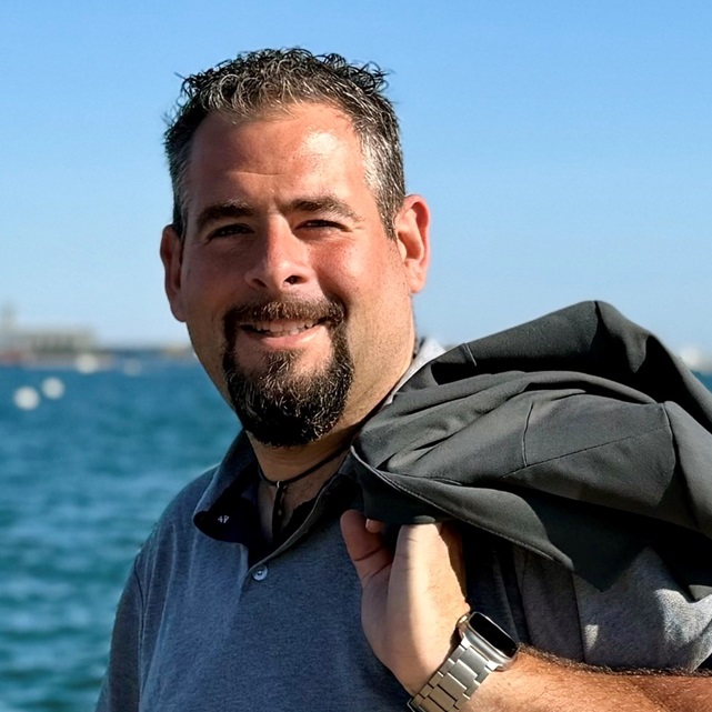 René Schmetz vor maritimer Kulisse mit dem Meer im Hintergrund.