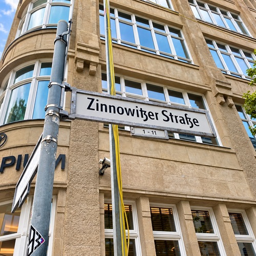 Straßenschild „Zinnowitzer Straße“ vor dem Gebäude des Lehrstandorts der Akkon Hochschule in Berlin-Mitte.