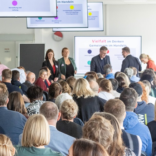 Blick auf die Teilnehmenden eines Workshops beim Symposium Berufliche Bildung der Johanniter in Hannover. Im Vordergrund sitzen zahlreiche Personen, während vorne ein Referent spricht.