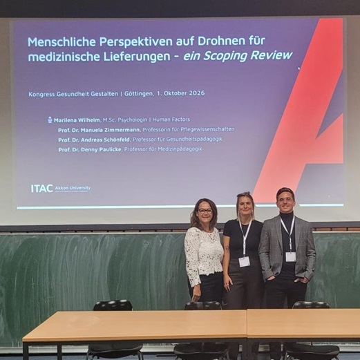Marilena Wilhelm mit einer weiteren Teilnehmerin vor der Präsentationsfolie zum Vortrag über menschliche Perspektiven auf medizinische Drohnenlieferungen beim Kongress Gesundheit Gestalten in Göttingen.